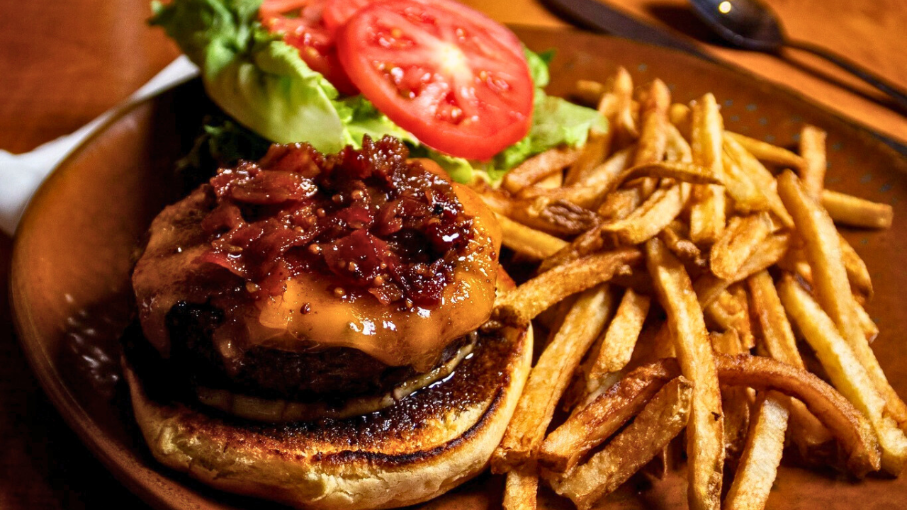 Gourmet Tavern Burger with cheddar, bacon jam, lettuce, tomato, and fries at Peter Allen Inn in Kinsman, Ohio.