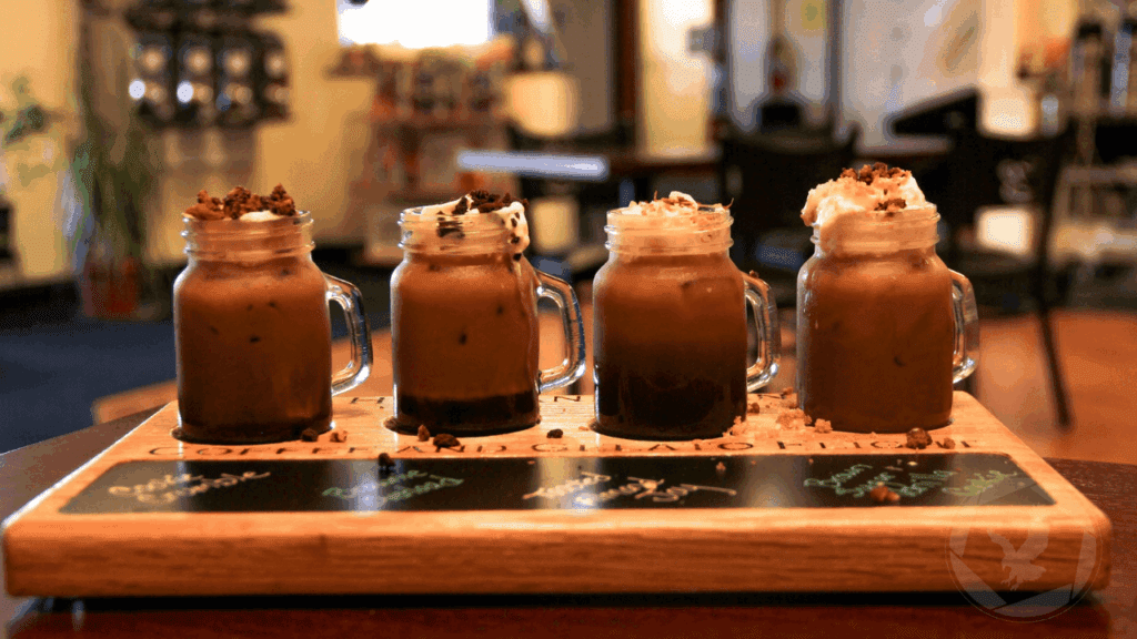 Coffee flight featuring four specialty iced drinks served in mason jars at The Howland Bean coffee shop in Howland, Ohio