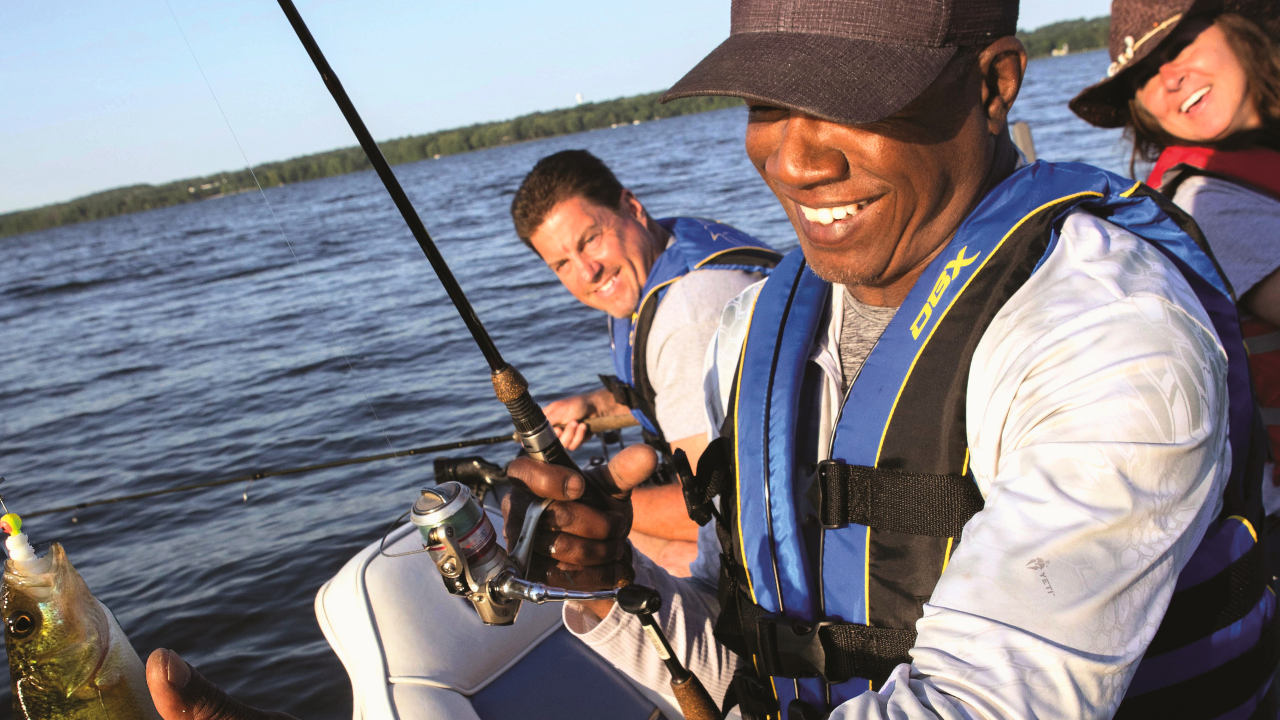 Group of friends fishing from a boat on Mosquito Lake in Northeast Ohio, enjoying a sunny day of outdoor recreation