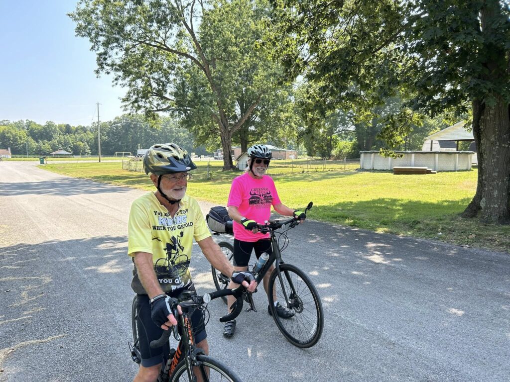 Three helmeted riders chatting on a neighborhood street during the Northeast Ohio Century bicycle tour near Cortland, Ohio.