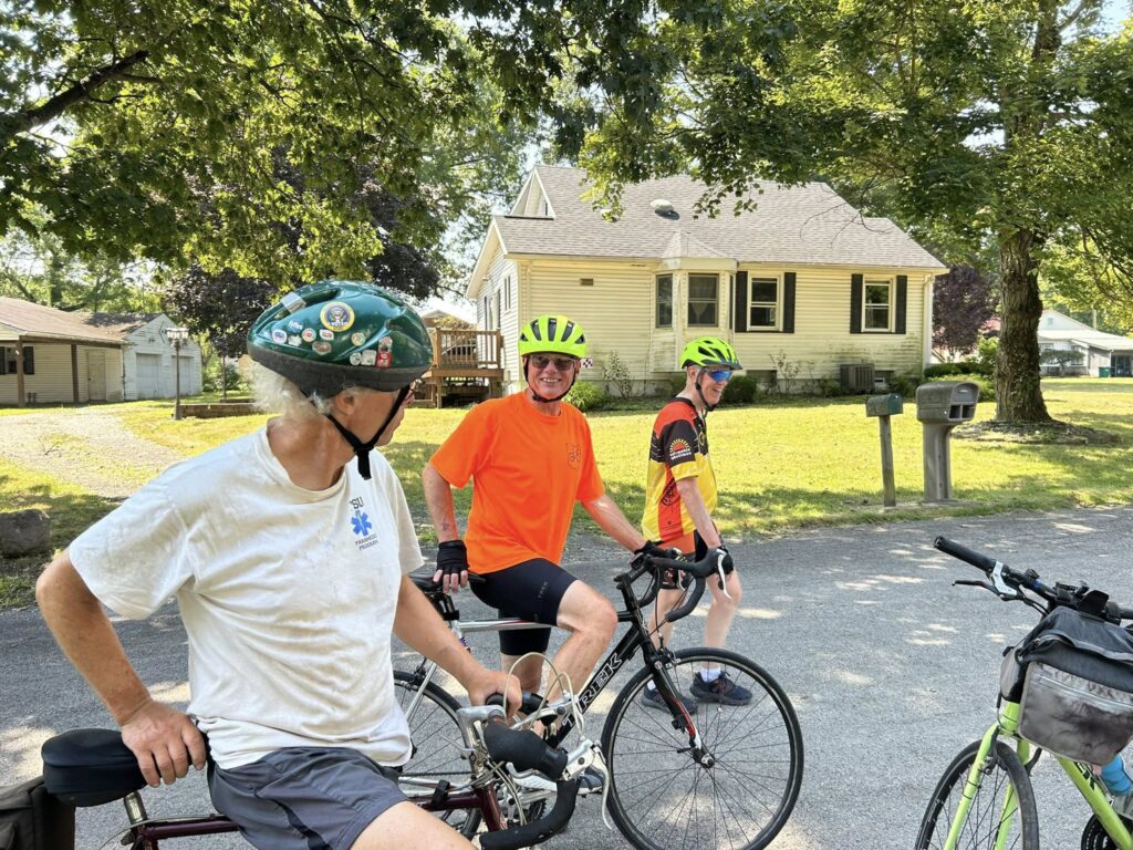 Two cyclists paused with their bikes beneath shade trees during the Northeast Ohio Century ride in Trumbull County, Ohio.