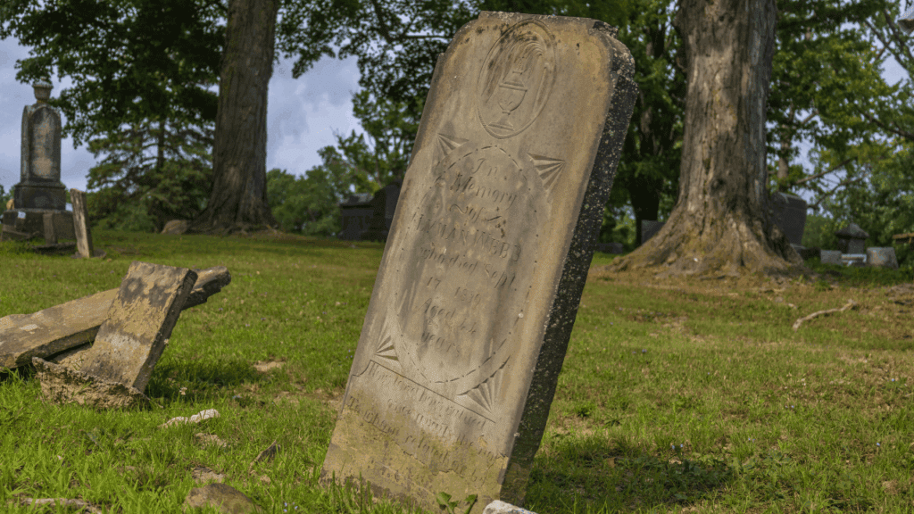 Weathered gravestone of War of 1812 veteran Lyman Webb leaning with age at Evergreen Cemetery in Johnston Township, Trumbull County, Ohio.