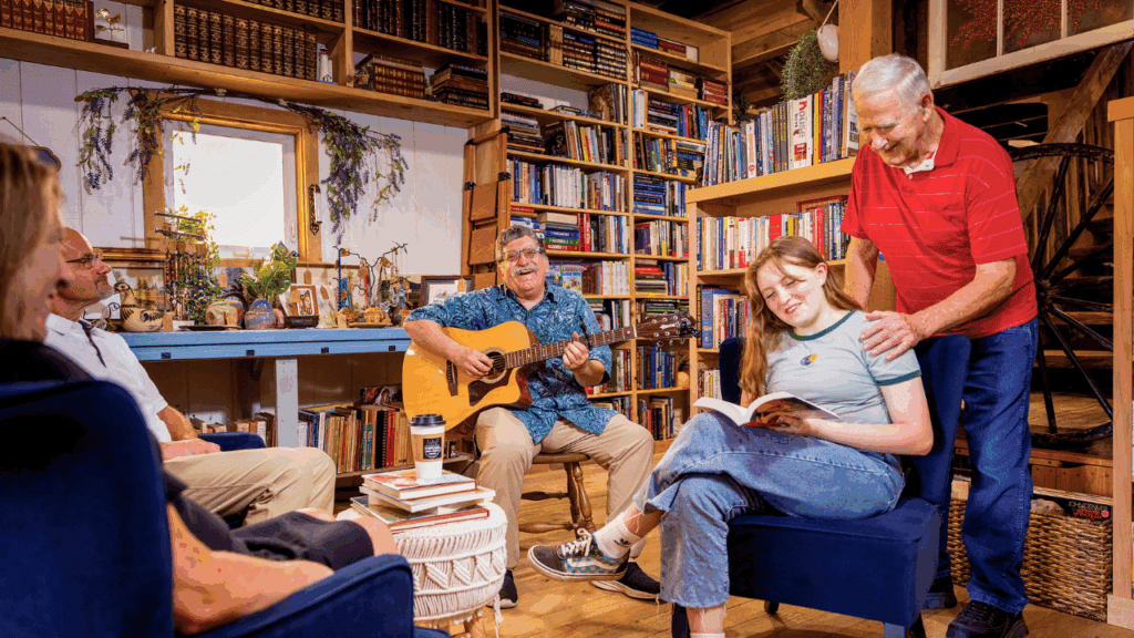 Inside Papa’s Book Shoppe in Cortland, Ohio: readers gather among floor-to-ceiling shelves while a guitarist plays in the cozy, wood-beam bookstore.