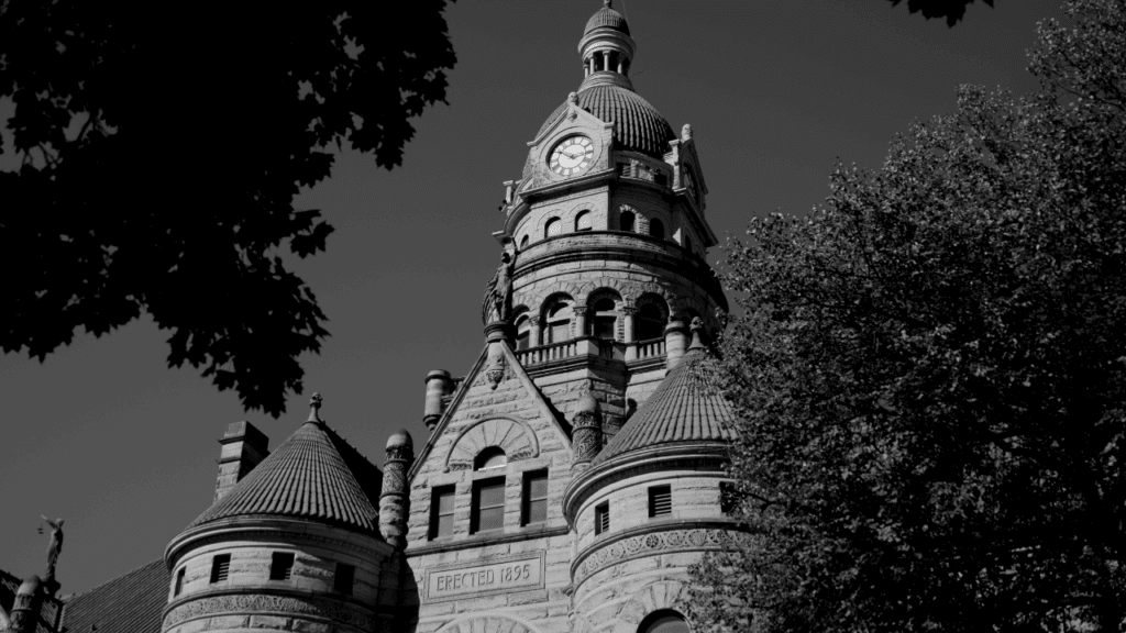 Romanesque clock tower of the Trumbull County Courthouse rising above trees on Courthouse Square in downtown Warren, Ohio.